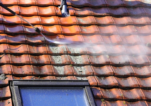 Team of cleaners washing off a roof with Pressure Washing in Peoria IL